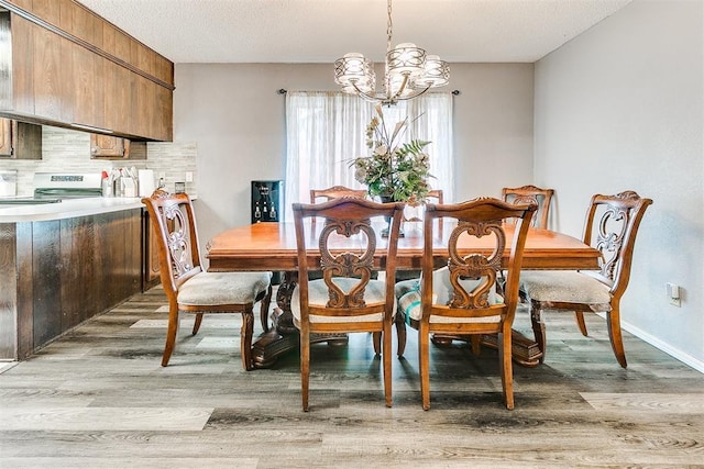 100 Three Oaks Dr, Midwest City, OK 73130 - dining area featuring a chandelier, light wood-style floors, and a textured ceiling