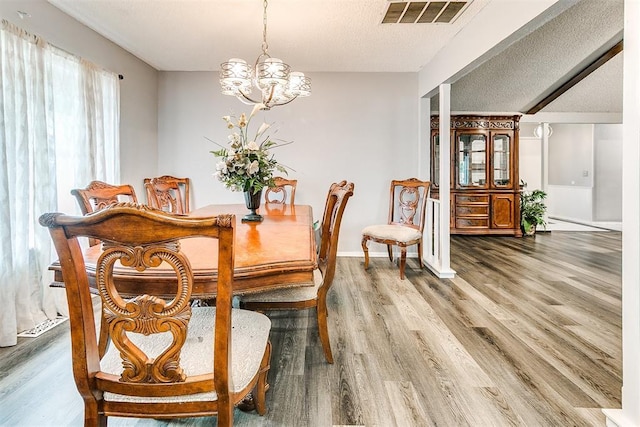 100 Three Oaks Dr, Midwest City, OK 73130 - dining space with wood finished floors, a chandelier, and a textured ceiling