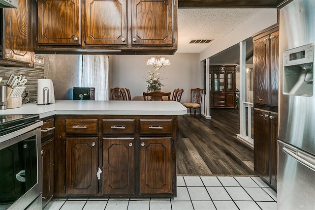 100 Three Oaks Dr, Midwest City, OK 73130 - kitchen with stainless steel appliances, a peninsula, light countertops, decorative backsplash, and light tile patterned floors