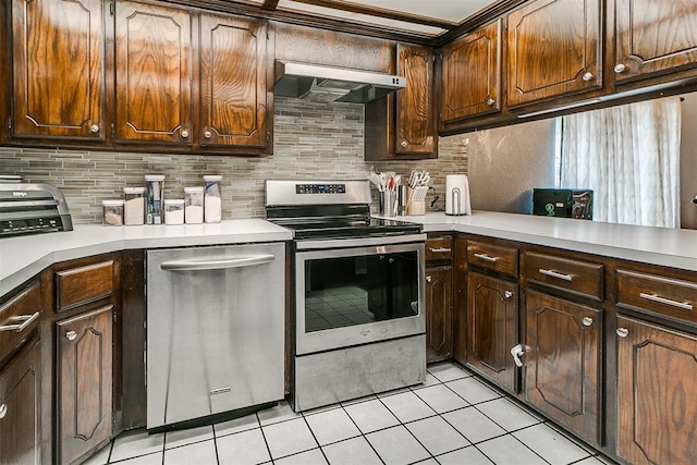 100 Three Oaks Dr, Midwest City, OK 73130 - kitchen featuring ventilation hood, stainless steel appliances, light tile patterned floors, and decorative backsplash