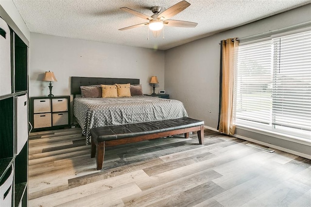 100 Three Oaks Dr, Midwest City, OK 73130 - bedroom featuring wood finished floors, a textured ceiling, and a ceiling fan