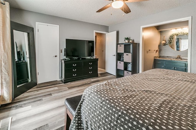 100 Three Oaks Dr, Midwest City, OK 73130 - bedroom featuring wood finished floors, ensuite bath, a textured ceiling, and a ceiling fan
