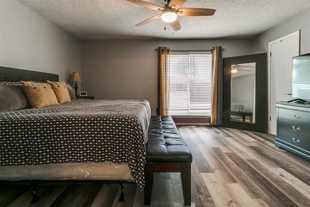 100 Three Oaks Dr, Midwest City, OK 73130 - bedroom featuring wood finished floors, a textured ceiling, and a ceiling fan