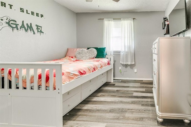 100 Three Oaks Dr, Midwest City, OK 73130 - bedroom featuring wood finished floors, a textured ceiling, and a ceiling fan