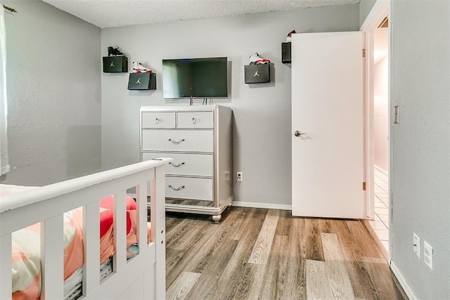 100 Three Oaks Dr, Midwest City, OK 73130 - bedroom featuring light wood-style flooring and a textured ceiling