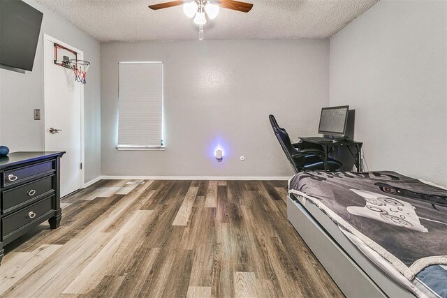 100 Three Oaks Dr, Midwest City, OK 73130 - bedroom with a textured ceiling, wood finished floors, and ceiling fan