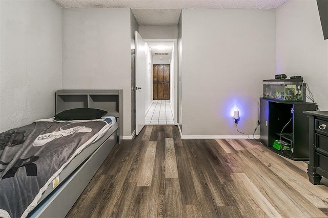 100 Three Oaks Dr, Midwest City, OK 73130 - bedroom with wood finished floors and a textured ceiling