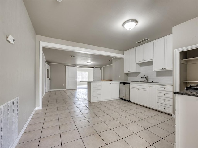 6617 NW 31st St, Bethany, OK 73008 - kitchen with stainless steel dishwasher, a peninsula, light tile patterned flooring, white cabinetry, and decorative backsplash