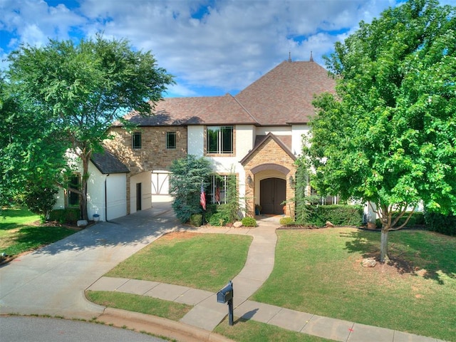 4109 Slate Bridge Rd, Edmond, OK 73034 - tudor-style house featuring stone siding, driveway, a front lawn, and stucco siding