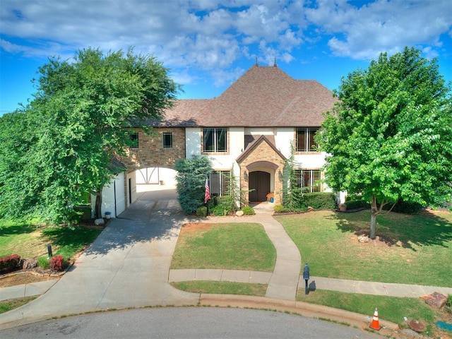 4109 Slate Bridge Rd, Edmond, OK 73034 - tudor-style house with concrete driveway, a front yard, and stone siding