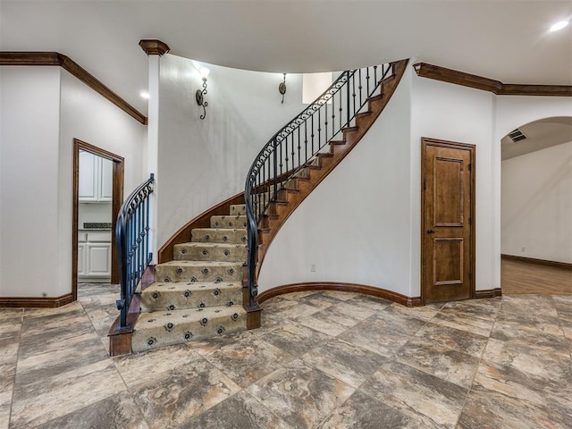 4109 Slate Bridge Rd, Edmond, OK 73034 - stairway with crown molding, arched walkways, stone finish flooring, and recessed lighting
