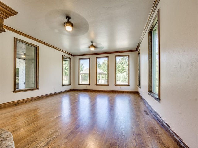 4109 Slate Bridge Rd, Edmond, OK 73034 - unfurnished room with healthy amount of natural light, crown molding, wood finished floors, and a ceiling fan