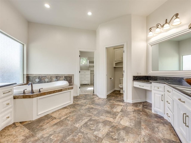 4109 Slate Bridge Rd, Edmond, OK 73034 - full bathroom featuring vanity, a bath, stone finish floors, and recessed lighting