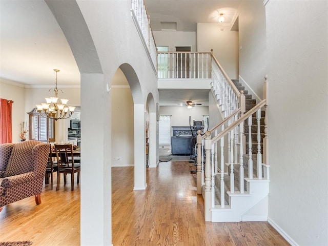 7300 NW 109th St, Oklahoma City, OK 73162 - entrance foyer featuring ceiling fan, arched walkways, stairway, a chandelier, and wood finished floors