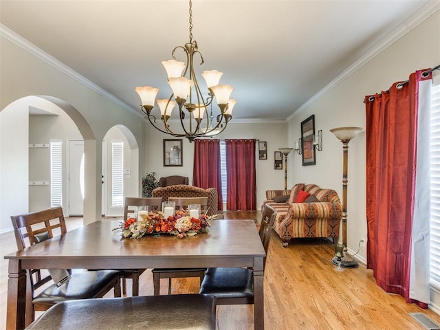 7300 NW 109th St, Oklahoma City, OK 73162 - dining room featuring arched walkways, crown molding, light wood finished floors, and a chandelier