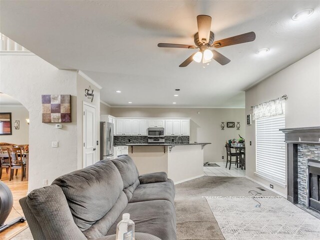 7300 NW 109th St, Oklahoma City, OK 73162 - living area featuring a ceiling fan, arched walkways, crown molding, a fireplace, and recessed lighting
