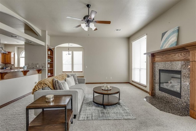 3000 Hampshire Ln, Oklahoma City, OK 73179 - living room with a ceiling fan, light carpet, arched walkways, and a high end fireplace