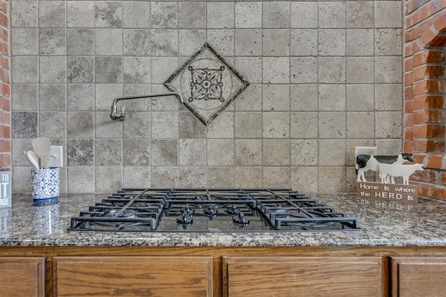 3000 Hampshire Ln, Oklahoma City, OK 73179 - kitchen view of pot filler, black gas stovetop, backsplash, stone countertops, and brown cabinets