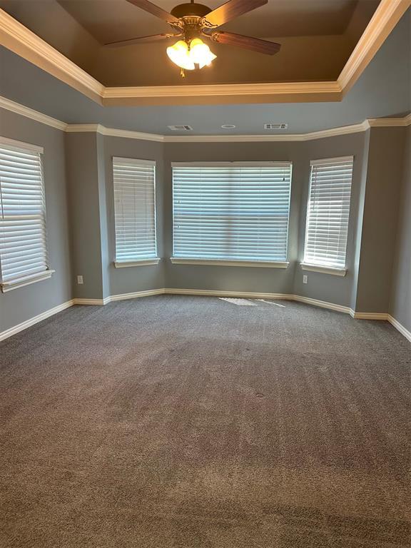 5024 SW 130th St, Oklahoma City, OK 73173 - spare room with a tray ceiling, ornamental molding, carpet, and ceiling fan