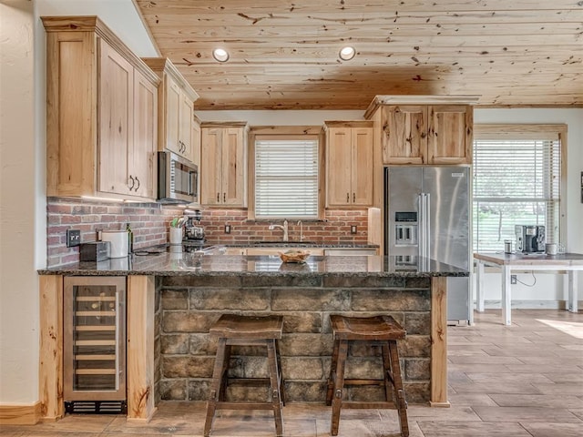 29490 County Road 180th Rd, Stillwater, OK 74075 - kitchen with wine cooler, appliances with stainless steel finishes, wooden ceiling, a peninsula, and a breakfast bar
