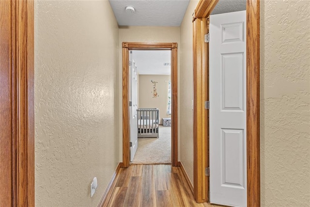3008 Fairway Dr, Weatherford, OK 73096 - hallway featuring a textured wall, wood finished floors, and a textured ceiling