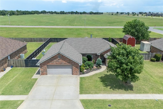 3008 Fairway Dr, Weatherford, OK 73096 - view of front of property featuring brick siding, an attached garage, driveway, a storage shed, and a view of rural / pastoral area