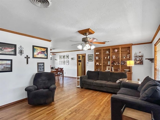 521 E Broadway St, Lexington, OK 73051 - living room featuring ceiling fan, ornamental molding, light wood-style floors, and a textured ceiling