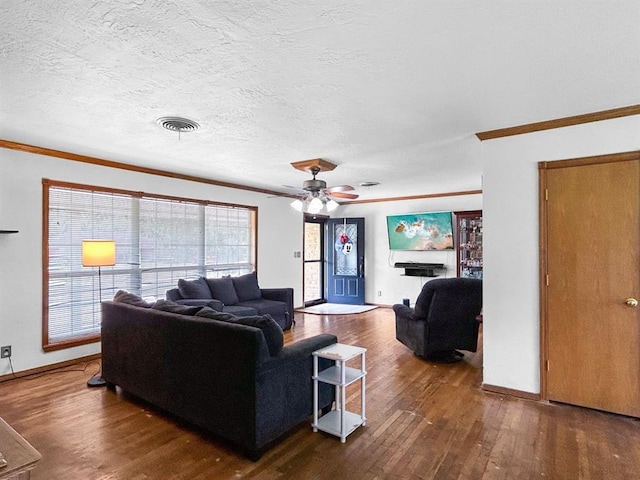 521 E Broadway St, Lexington, OK 73051 - living area with ornamental molding, hardwood / wood-style flooring, ceiling fan, a textured ceiling, and a fireplace