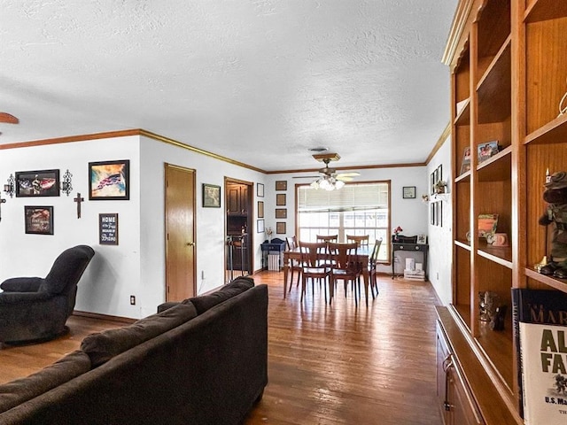 521 E Broadway St, Lexington, OK 73051 - living room with a ceiling fan, a textured ceiling, dark wood-style floors, crown molding, and built in features