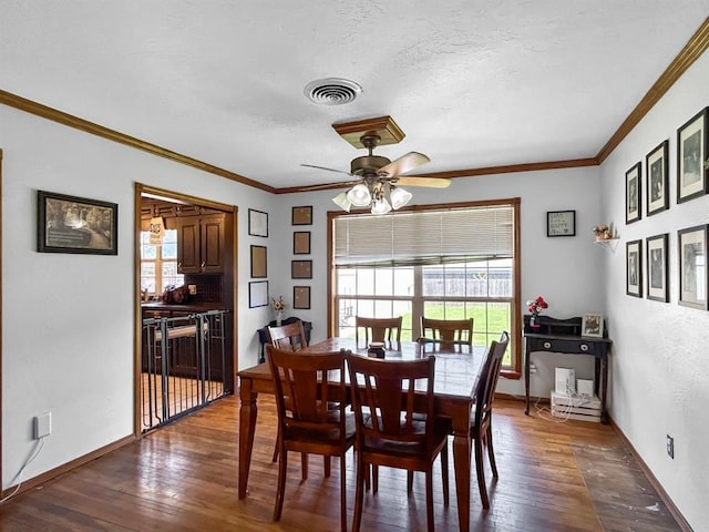 521 E Broadway St, Lexington, OK 73051 - dining space featuring healthy amount of natural light, ceiling fan, dark wood finished floors, crown molding, and a textured ceiling