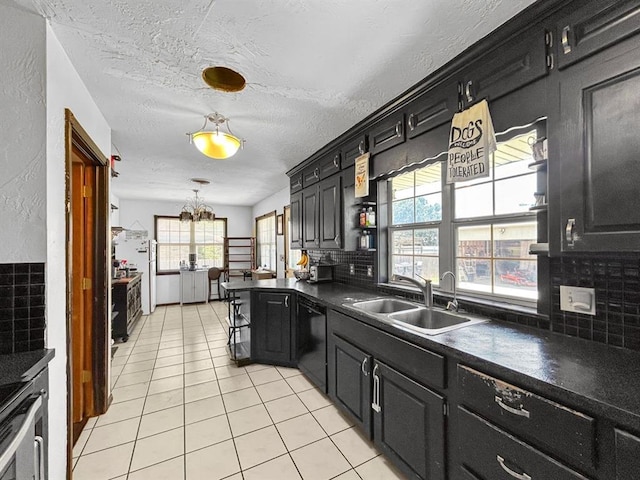521 E Broadway St, Lexington, OK 73051 - kitchen featuring dishwasher, dark countertops, light tile patterned flooring, tasteful backsplash, and a textured ceiling