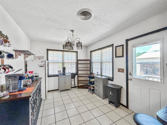 521 E Broadway St, Lexington, OK 73051 - kitchen featuring a textured ceiling, freestanding refrigerator, a chandelier, and light tile patterned floors