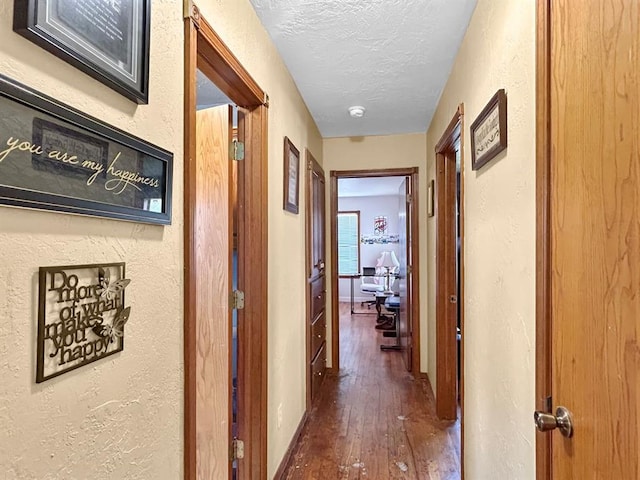 521 E Broadway St, Lexington, OK 73051 - corridor featuring wood finished floors, a textured ceiling, and a textured wall