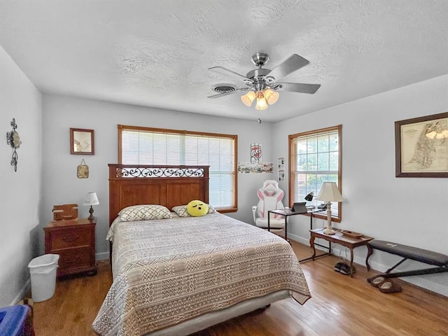 521 E Broadway St, Lexington, OK 73051 - bedroom featuring wood finished floors, a ceiling fan, and a textured ceiling