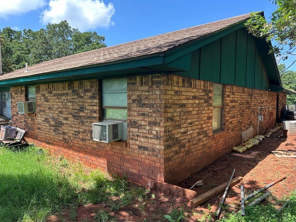 28197 Buck Townes Rd, Macomb, OK 74852 - view of side of property with board and batten siding, brick siding, roof with shingles, and cooling unit