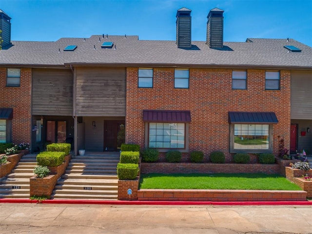 11300 N Pennsylvania Ave Unit 120, Oklahoma City, OK 73120 - view of property featuring a chimney, brick siding, stairs, and roof with shingles