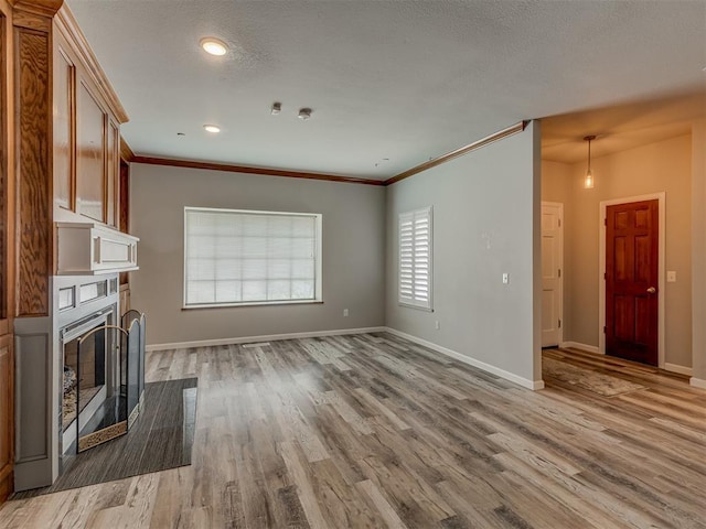 11300 N Pennsylvania Ave Unit 120, Oklahoma City, OK 73120 - unfurnished living room featuring light wood finished floors, a glass covered fireplace, ornamental molding, and recessed lighting