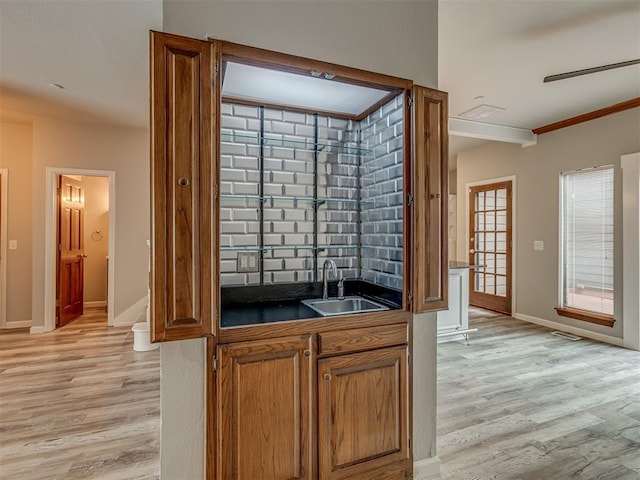 11300 N Pennsylvania Ave Unit 120, Oklahoma City, OK 73120 - kitchen featuring dark countertops, light wood finished floors, brown cabinets, and crown molding