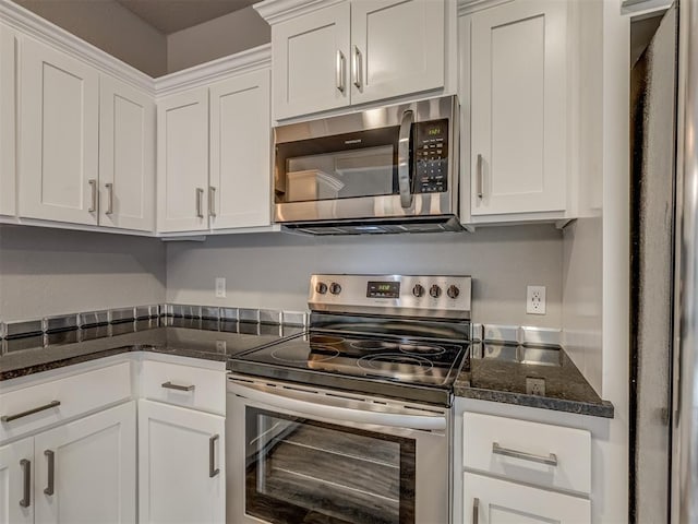 11300 N Pennsylvania Ave Unit 120, Oklahoma City, OK 73120 - kitchen with appliances with stainless steel finishes, white cabinets, and dark stone counters