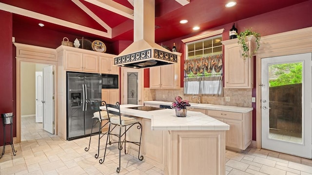 704 Capri Pl, Edmond, OK 73034 - kitchen with black appliances, tile countertops, tasteful backsplash, recessed lighting, and island exhaust hood