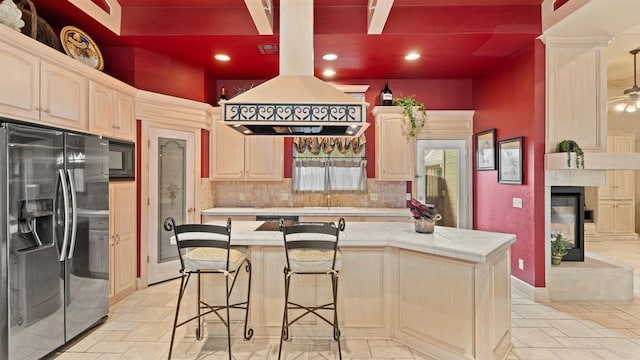 704 Capri Pl, Edmond, OK 73034 - kitchen featuring refrigerator with ice dispenser, tile counters, a kitchen island, black microwave, and decorative backsplash