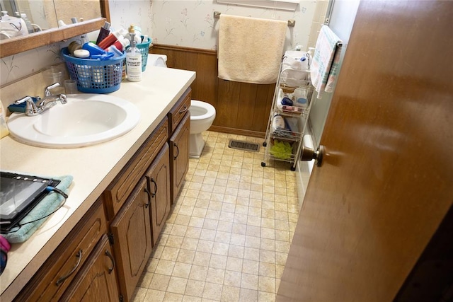 5712 NW 42nd Ter, Warr Acres, OK 73122 - bathroom with a wainscoted wall, wallpapered walls, vanity, and wooden walls