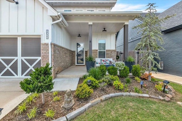 2033 Marsala Dr, Edmond, OK 73034 - doorway to property with brick siding, board and batten siding, and a porch