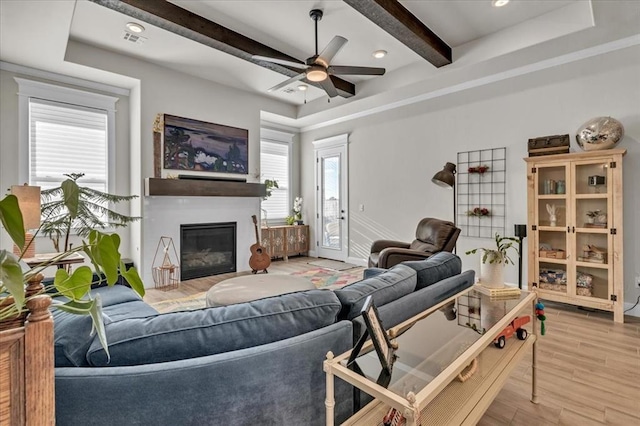 2033 Marsala Dr, Edmond, OK 73034 - living room with beam ceiling, a glass covered fireplace, wood finished floors, and ceiling fan