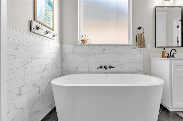 2033 Marsala Dr, Edmond, OK 73034 - bathroom with tile patterned floors, a soaking tub, vanity, and tile walls