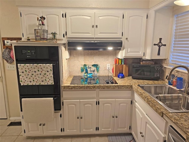 5712 Lawson Ln, Oklahoma City, OK 73132 - kitchen with black appliances, under cabinet range hood, white cabinetry, decorative backsplash, and a warming drawer