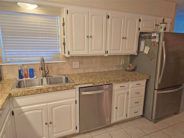 5712 Lawson Ln, Oklahoma City, OK 73132 - kitchen with appliances with stainless steel finishes, light tile patterned floors, white cabinetry, and backsplash