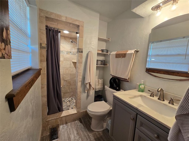 5712 Lawson Ln, Oklahoma City, OK 73132 - full bath with wood finished floors, vanity, a tile shower, a textured wall, and healthy amount of natural light