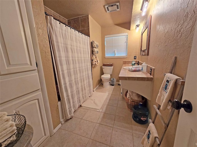 5712 Lawson Ln, Oklahoma City, OK 73132 - bathroom featuring tile patterned floors, a textured wall, vanity, and shower / bathtub combination with curtain