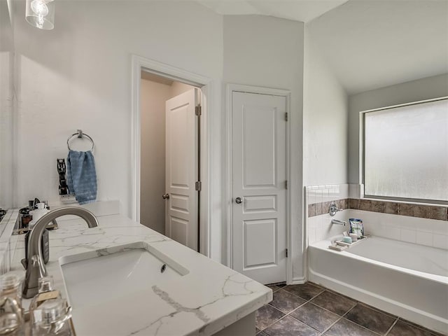 5112 NW 163rd St, Edmond, OK 73013 - bathroom featuring a garden tub, vaulted ceiling, double vanity, and tile patterned flooring